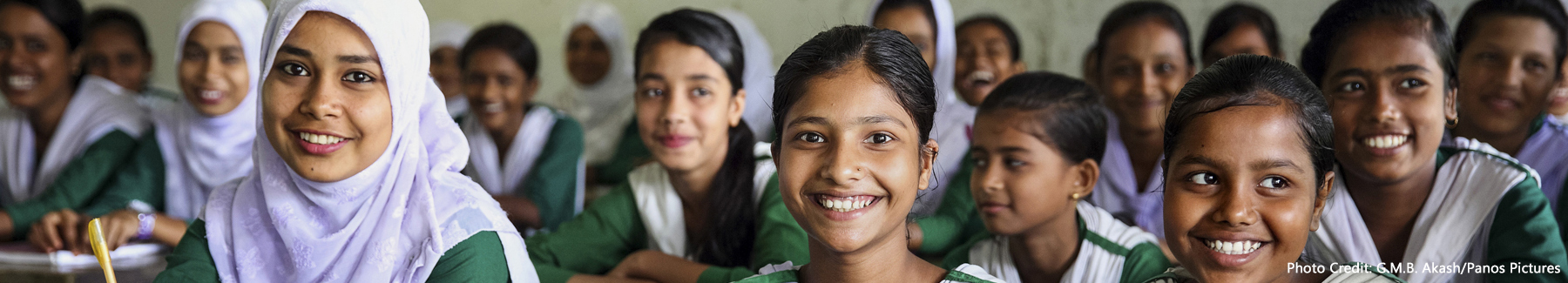 Schoolgirls sitting on newly installed benches at the Jongal Bari High school.